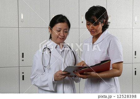 Lady doctor and nurse comparing notes. Lady doctor and nurse comparing notes. 12528398
