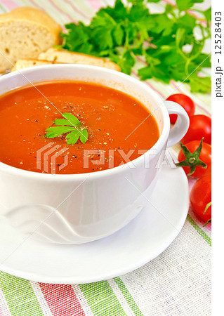 Soup tomato in bowl with tomatoes on linen napkin Soup tomato in bowl with tomatoes on linen napkin 12528403