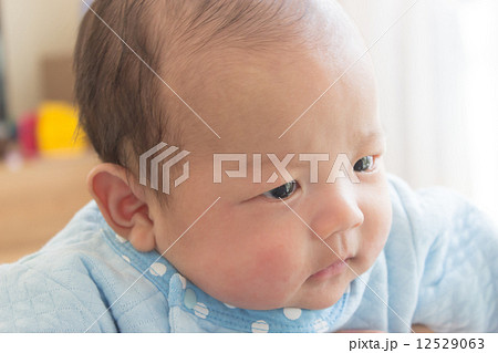 生後2ヶ月 赤ちゃん しかめっ面の写真素材