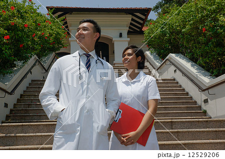 Male Chinese doctor and Malay nurse looking skyward. Male Chinese doctor and Malay nurse looking skyward. 12529206
