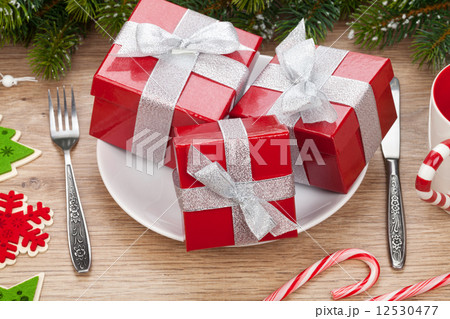 Gift boxes on plate, fir tree and christmas decor 12530477