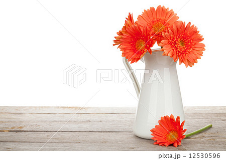 Orange gerbera flowers in pitcher 12530596