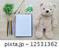 Blank paper, color paint and bear doll on the wood table - Top view 12531362