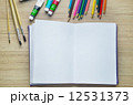 Blank paper, Acrylic paint and colorful pencils on the wood tabl 12531373