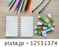Blank paper, Acrylic paint and colorful pencils on the wood tabl 12531374