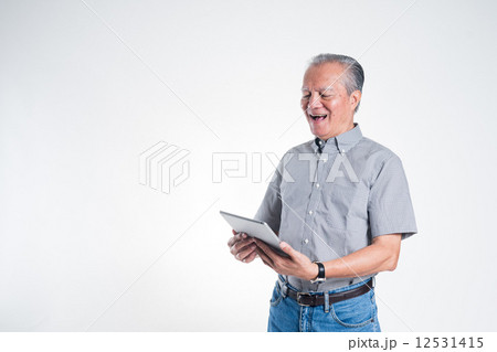 Old man holding tablet looking happy Old man holding tablet looking happy 12531415