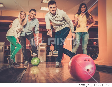 Group of four young smiling people playing bowling 12551835