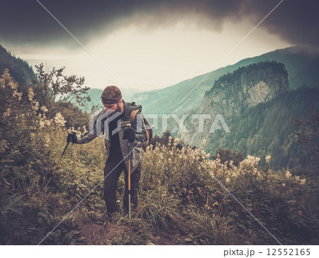 Man with hiking equipment walking in mountain forest Man with hiking equipment walking in mountain forest 12552165