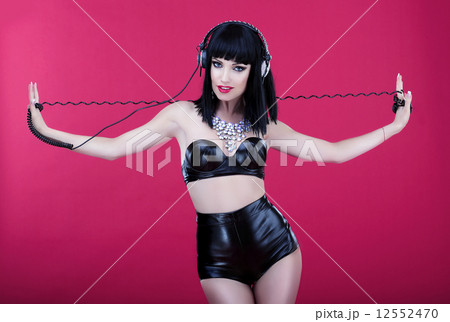 Clubbing. Woman with Headphones in Leather Latex Costume 12552470