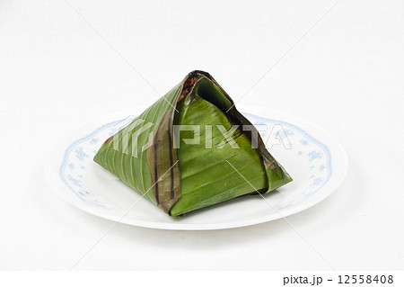 Unopened simple and original traditional nasi lemak wrapped in banana leaf served on plate. 12558408