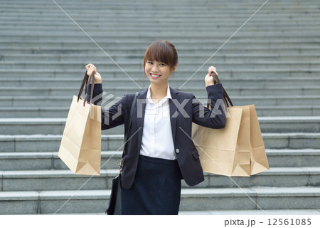 One young Chinese office lady showing off her shopping buys in front of steps 12561085
