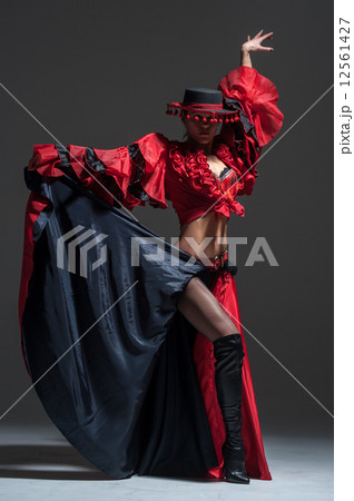 Woman in beautifull red dress dancing in a studio Woman in beautifull red dress dancing in a studio 12561427