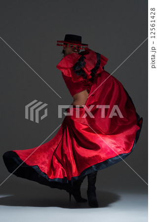 Woman in beautifull red dress dancing in a studio Woman in beautifull red dress dancing in a studio 12561428