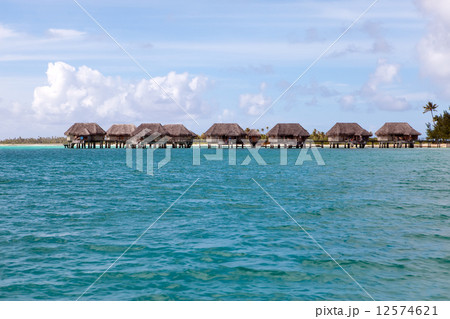 seacoast with palm trees and small houses on water. seacoast with palm trees and small houses on water. 12574621
