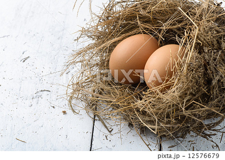 Eggs in nest on white wooden table. 12576679