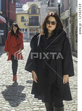Two women in jackets on a street 12582419