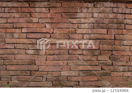 Old dark stucco brown and painted red brick wall background 12584966