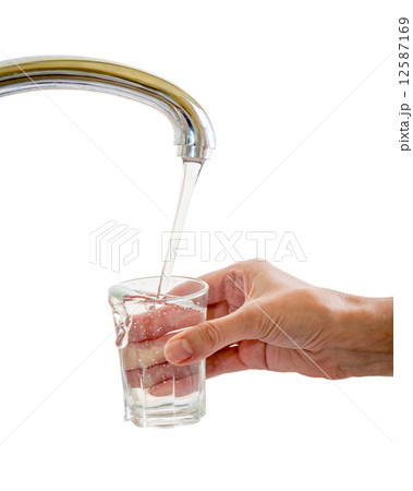 Hand filing glass with water from tap isolated 12587169