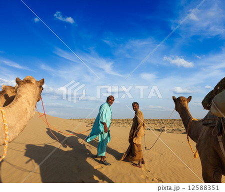 Two cameleers (camel drivers) with camels in dunes of Thar deser Two cameleers (camel drivers) with camels in dunes of Thar deser 12588351