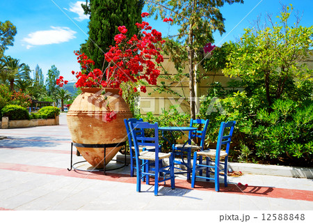 The amphora with flowers and traditional Greek table and chairs 12588848