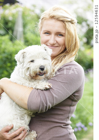 Portrait Of Woman With Pet Dog In Garden 12594631
