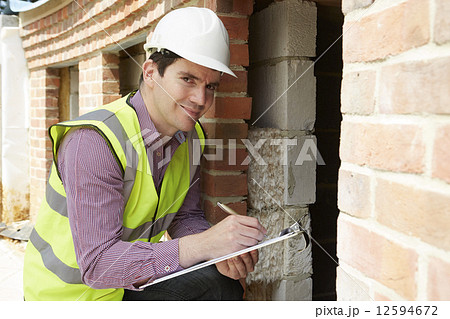 Architect Checking Insulation During House Construction Architect Checking Insulation During House Construction 12594672