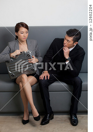 Businessman looking at businesswoman with briefcase Businessman looking at businesswoman with briefcase 12602204