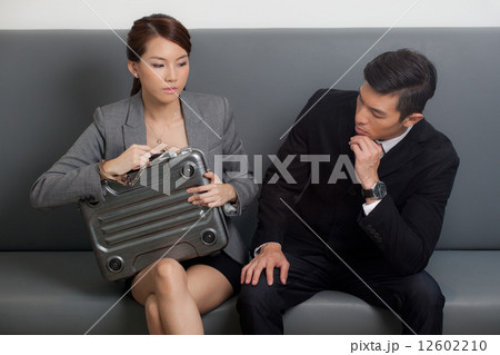 Businessman looking at businesswoman with briefcase Businessman looking at businesswoman with briefcase 12602210