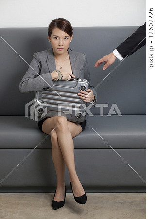 Businessman reaching for briefcase of businesswoman Businessman reaching for briefcase of businesswoman 12602226