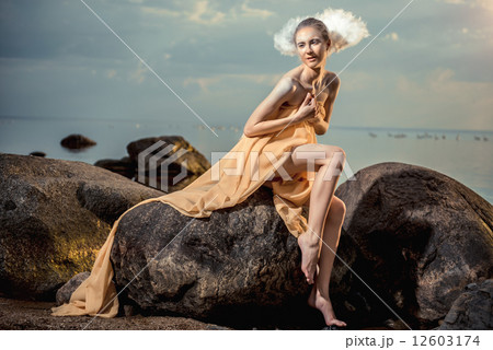 Young beautiful woman as swan posing on the beach at sunset 12603174