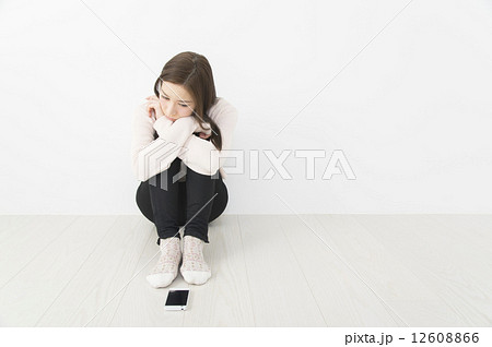 スマホの前で連絡を待つ女性　連絡が来ない 12608866