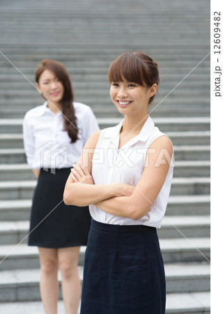 2 young successful chinese office lady in front of steps outdoor 12609482
