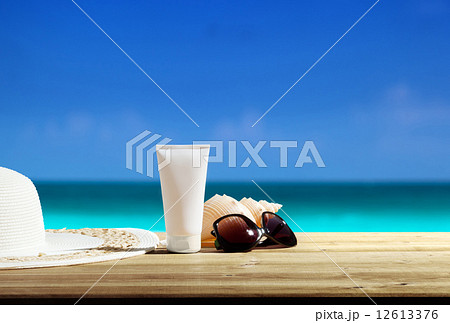 Sun lotion and sunglasses on the beach Sun lotion and sunglasses on the beach 12613376