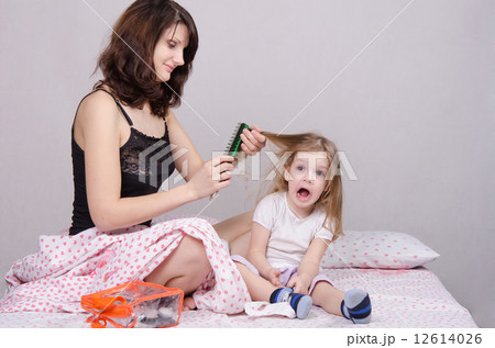 Mom combing hair-year old daughter 12614026