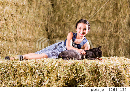 Bavarian girl playing with cat on hayloft 12614135