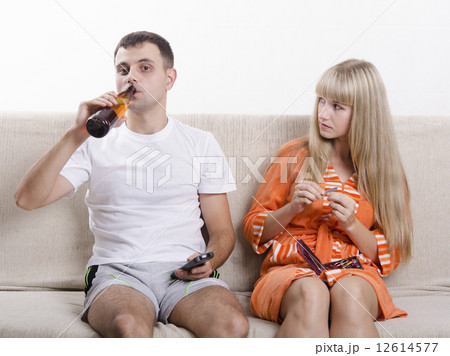 He drinking beer, she looks at him reproachfully 12614577