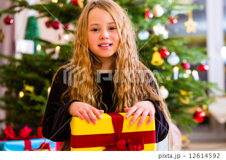 Girl opening present on Christmas day 12614592