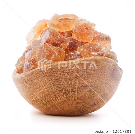 Brown cane caramelized lump sugar in wooden bowl isolated on whi Brown cane caramelized lump sugar in wooden bowl isolated on whi 12617801