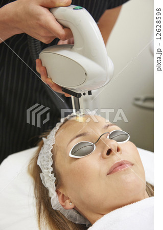 Beautician Carrying Out Intense Pulse Light Treatment 12628598