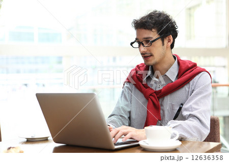 カフェで仕事する男性 12636358