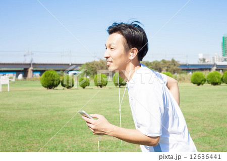 音楽を聞きながら走る男性 12636441