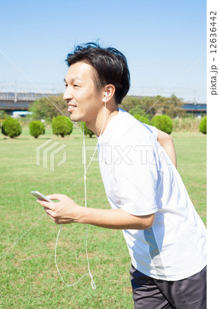 音楽を聞きながら走る男性 12636442