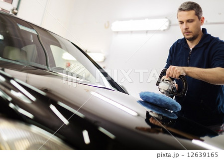 Man on a car wash polishing car with a polish machine 12639165