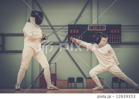 Little girl fencer and her trainer Little girl fencer and her trainer 12639353