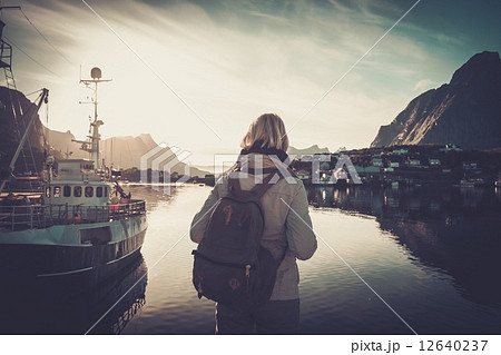 Woman traveler looking at sunset in Reine village, Norway 12640237