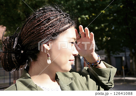 眩しそうなブレードヘアの女性の写真素材