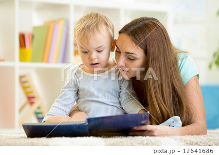 mother reads a book to kid at home mother reads a book to kid at home 12641686