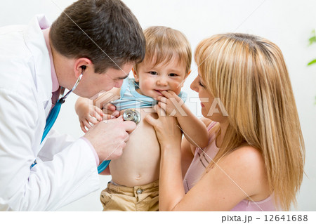 Pediatrician male doctor examining child. Mother holding baby. Pediatrician male doctor examining child. Mother holding baby. 12641688