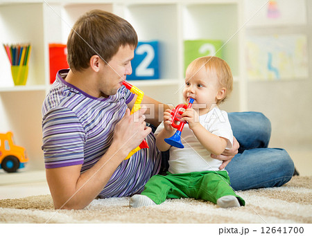 Happy family dad and son play musical toys Happy family dad and son play musical toys 12641700