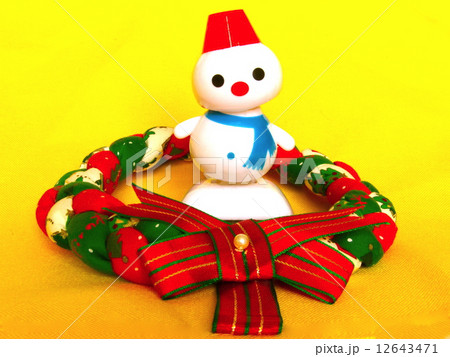 首を傾げる雪だるまとクリスマスリース 12643471